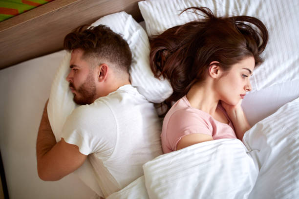 Couple in bed, emotional distance
